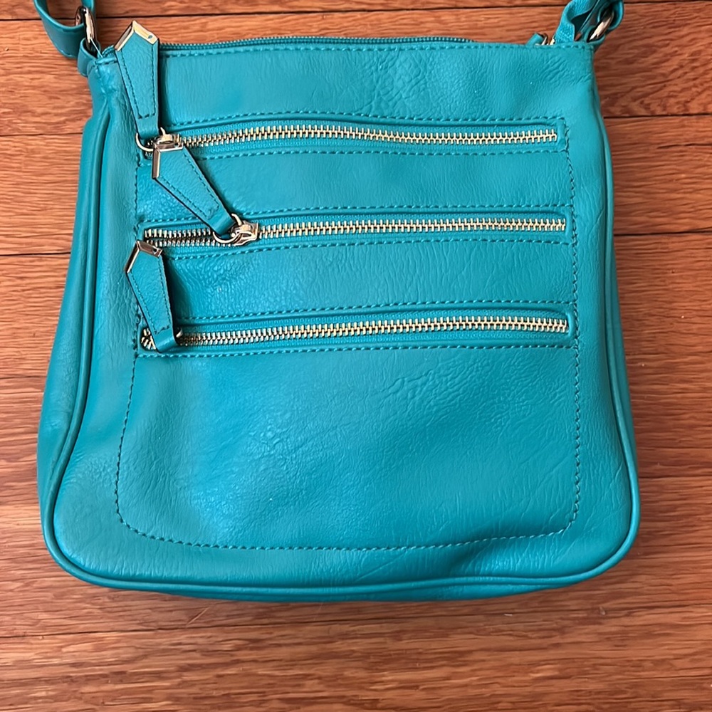 Teal cross body, NWOT, vegan leather. Incredible amount of storage!!